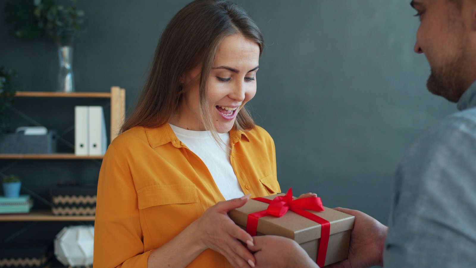 Woman delighted to receive a thoughtfully wrapped gift from a friend