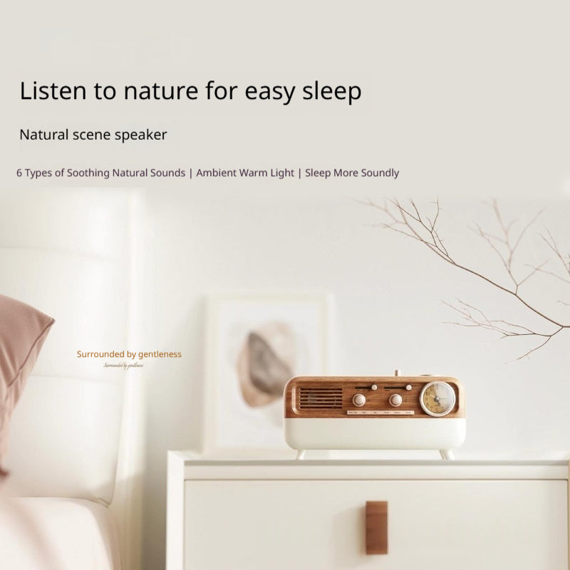 Lifestyle composition of the retro Bluetooth speaker on a nightstand styled with linens and a framed picture