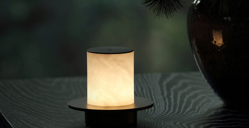 Cordless natural alabaster table lamp glowing warm on a dark table