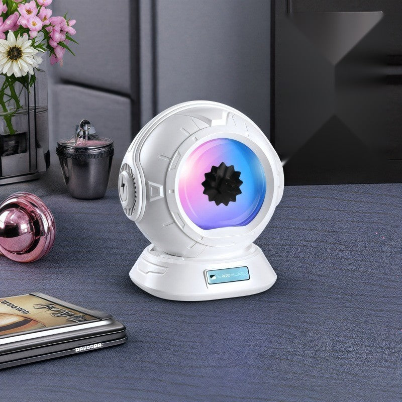 Ferrofluid Bluetooth speaker on a styled desk with fresh flowers and books