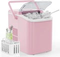 Portable Countertop Ice Maker in soft pink with carry handle and transparent lid open, basket full of bullet ice cubes, ice scoop, and a mojito-style green drink garnished with rosemary.