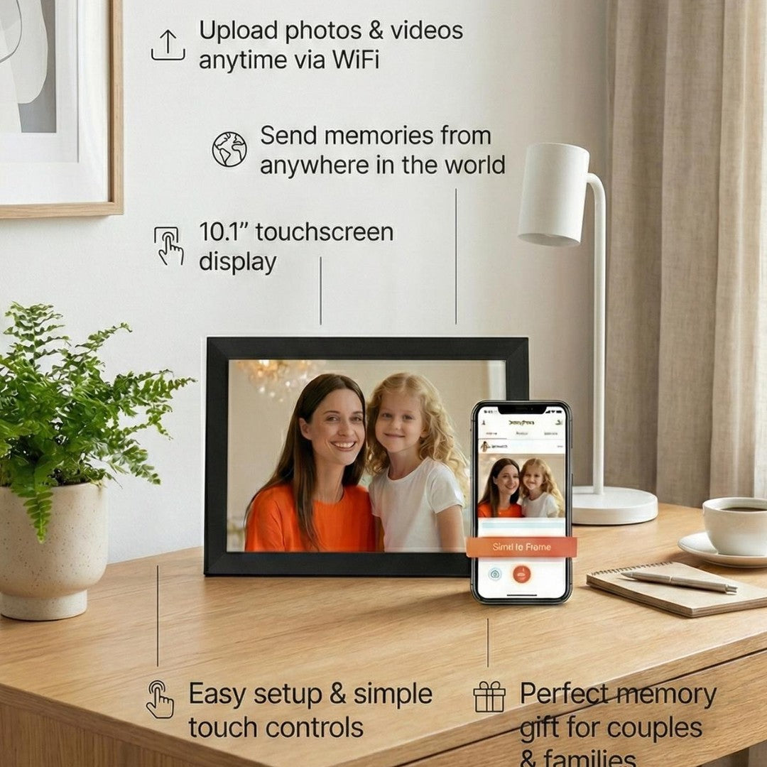 Smart WiFi digital photo frame 10.1 inch black bezel on wooden desk displaying mother and daughter, next to smartphone showing Frameo app Send to Frame screen